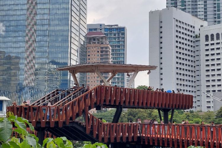 Hujan yang mengguyur kawasan Sudirman, Jakarta, tak mengurungkan tekat para pemburu foto di Jembatan Penyeberangan Phinisi Karet Sudirman pada Sabtu (12/3/2022) siang. 