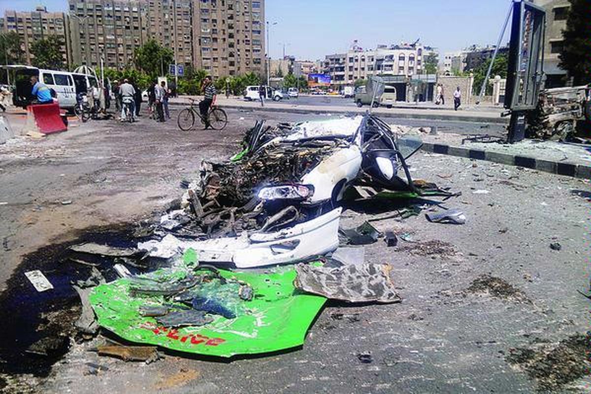 Bangkai mobil yang hancur dilindas tank ini tergeletak di jalanan dekat kamp pengungsi Palestina di Yarmouk, Damaskus selatan, Suriah, Sabtu (21/7). Foto diambil warga setelah pertempuran sengit antara tentara pemerintah dan pasukan oposisi terjadi di daerah itu.