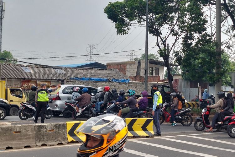 Petugas mengatur lalu lintas di u-turn Vittoria di Jalan Daan Mogorlt, Rawa Buaya, Cengkareng, Jakarta Barat, pada Jumat (2/12/2022).