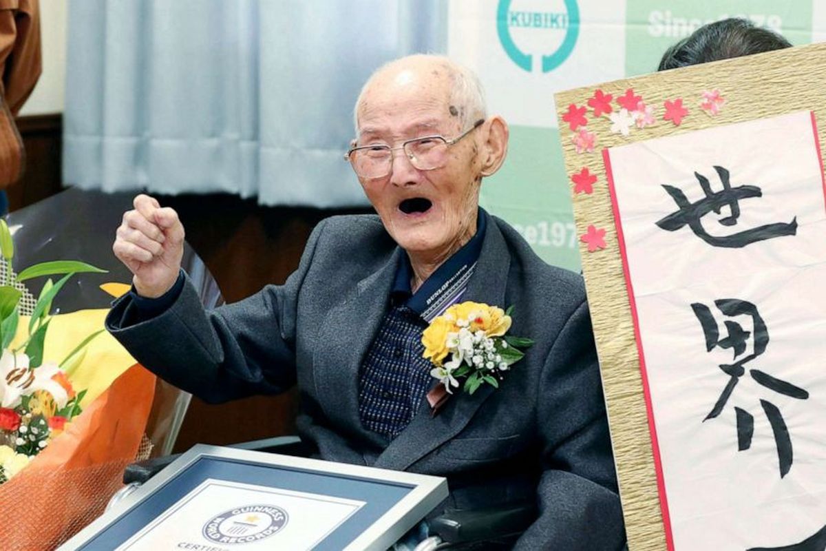 Chitetsu Watanabe (112) berpose bersama kaligrafi yang dia buat sendiri, setelah dianugerahi gelar pria tertua di dunia versi Guinness World Records, di Joetsu, prefektur Niigata, Jepang utara, Rabu (12/2/2020). 