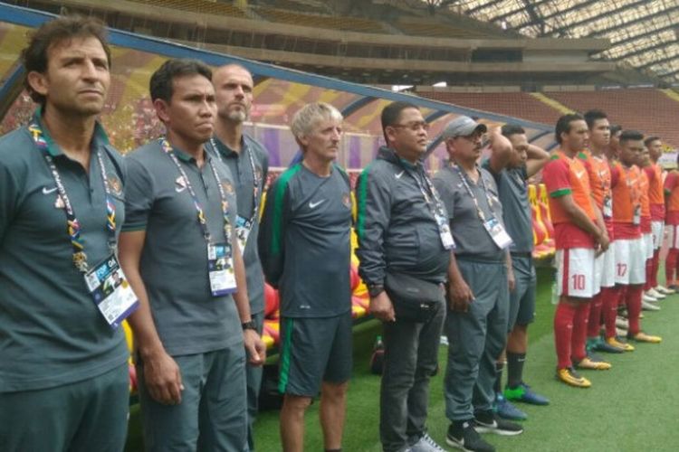 Pelatih tim nasional U-22 Indonesia, Luis Milla (paling kiri), didampingi asisten pelatih, Bima Sakti, menyanyikan lagu kebangsaan dalam laga perdana SEA Games 2017.