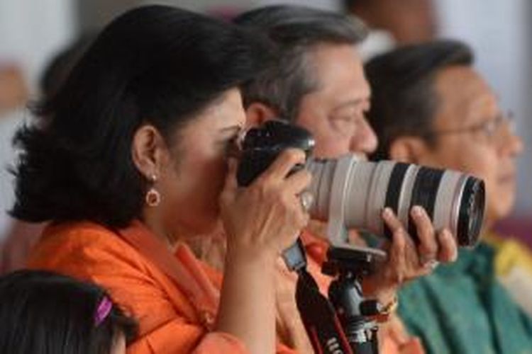 Ibu Negara Ani Yudhoyono memotret dengan kamera DSLR disamping Presiden Susilo Bambang Yudhoyono (tengah) dan Wakil Presiden Boediono (kanan) saat parada Hari Kemerdekaan di Jakarta, 18 Agustus 2013. AFP PHOTO / ADEK BERRY / FILES