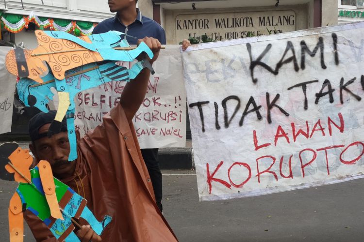 Salah satu peserta aksi solidaritas untuk Novel Baswedan saat memainkan wayang di depan Balai Kota Malang, Selasa (11/4/2017)