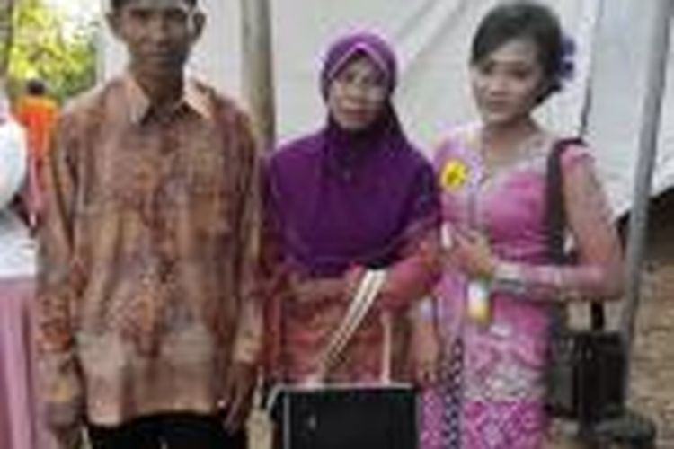 Darwati (23) (kanan), foto bersama keluarganya di sela prosesi wisuda. Darwati yang bekerja sebagai Pembantu Rumah Tangga itu berhasil menyabet lulusan terbaik, dengan IPK 3,68.