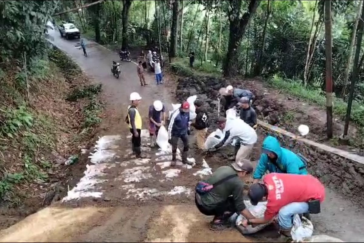 Sejumlah pekerja tengah mengurus tanjakan Purut di Kecamatan Kadupandak, Kabupaten Cianjur, Jawa Barat, Selasa (10/12/2024). Jalur penghubung lintas selatan ini sebelumnya ambles akibat pergerakan tanah.