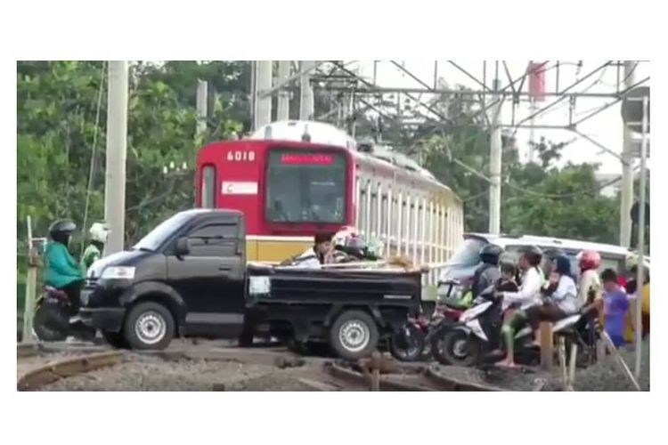Tangkapan layar dari video viral mengenai pengguna jalan yang lintasi rel saat KRL melaju.