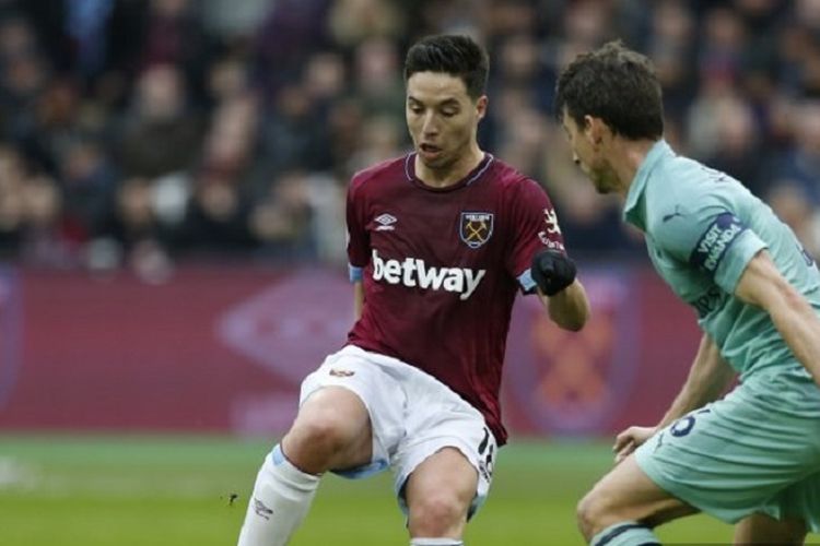 Gelandang West Ham United, Samir Nasri (kiri), dijaga bek Arsenal, Laurent Koscielny, dalam pertandingan Liga Premier Inggris di Stadion London, 12 Januari 2019.