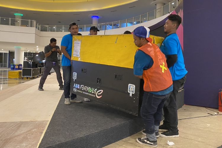 Kru marshal Formula E dibantu relawan saat melakukan pengemasan barang