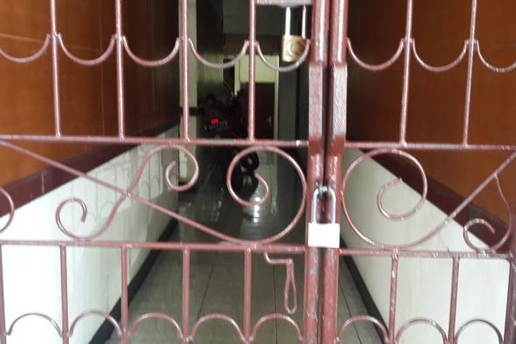 Pagar rumah kos Deudeuh Alfi Sahrin (26) di 15 C Tebet Timur, Jakarta Selatan, dipasangi gembok, Senin (20/4/2015). Pemasangan gembok di pagar tersebut guna memperketat penjagaan agara warga tidak lagi keluar masuk rumah kos yang bertingkat lima tersebut.