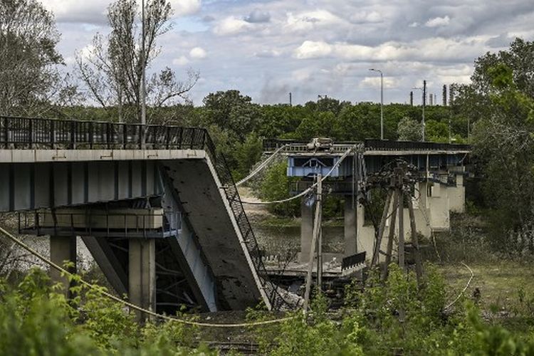 Sebuah gambar yang diambil pada 22 Mei 2022, menunjukkan jembatan yang hancur yang menghubungkan kota Lysychansk dengan kota Severodonetsk di wilayah Donbas, Ukraina timur, di tengah invasi Rusia ke Ukraina.