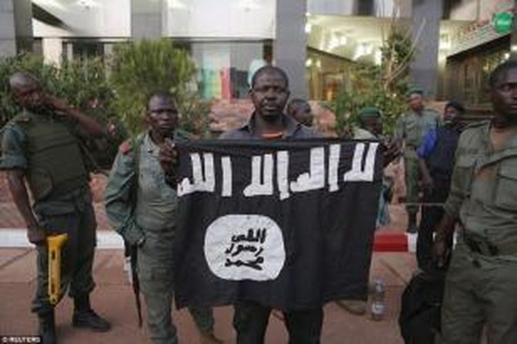 Seorang petugas keaman Mali memperlihatkan sebuah bendara para penyerang. Kelompok penyerang itu terkait dengan Al Qaeda.