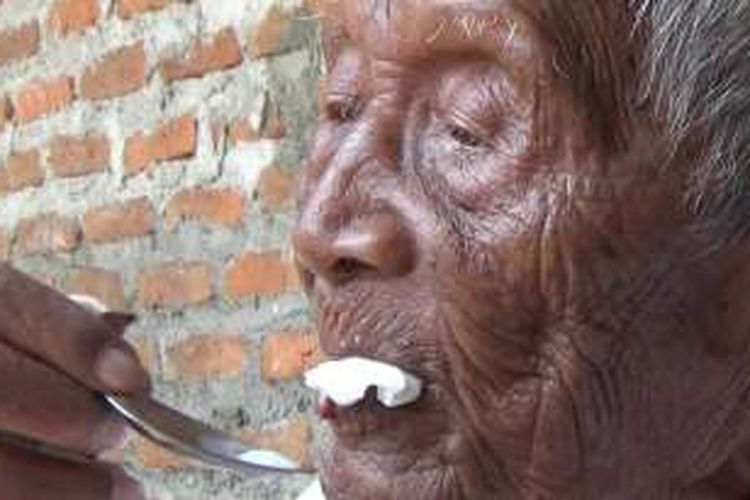 Mbah Gotho sedang makan es krim di teras rumahnya, Senin (29/8/2016)