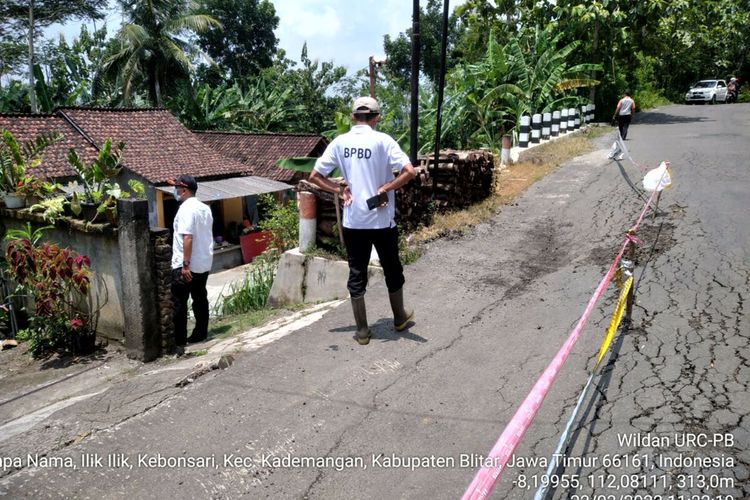 Petugas BPBD Kabupaten Blitar memeriksa jalan amblas yang diduga akibat fenomena tanah bergerak di Desa Kebonsari, Kecamatan Kademangan, Rabu (23/3/2022)