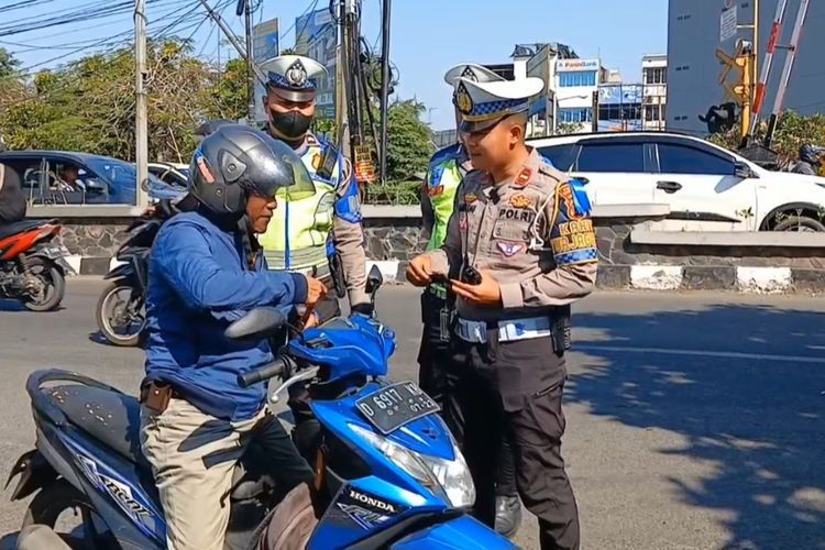 Seorang pengendara motor yang ditilang polisi di perlintasan rel kereta api Tuparev, Karawang, Jawa Barat, mengancam menelepon jenderal.