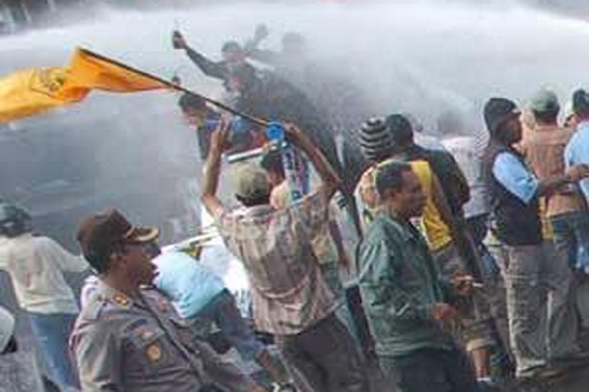 Jip yang ditumpangi pasangan Abdul Gafur-Abd Rahim Fabanyo disemprot watercanon dalam aksi unjukrasa di depan Kantor Gubernur Maluku Utara, Sabtu (7/6). Massa Gafur yang marah akhirnya melempari polisi dengan batu. Namun bentrokan berhasil dihentikan setelah berlangsung sekitar lima menit.