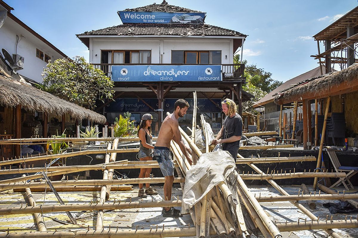 Sejumlah warga asing membersihkan puing-puing atap restorannya yang runtuh pascagempa bumi di kawasan wisata Gili Trawangan, Lombok Utara, NTB, Rabu (8/8/2018). Sejumlah fasilitas publik untuk wisatawan seperti restoran, hotel, jeti pelabuhan dan jaringan listrik rusak terdampak akibat gempa.