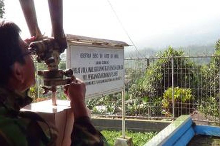 Sudrajat, Kepala Pos Pengamatan Gunung Slamet di Desa Gambuhan, Pemalang, Jawa Tengah menggunakan teropong mengamati Gunung Slamet.