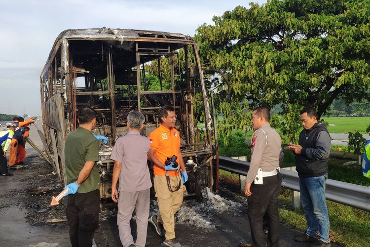 Aparat kepolisian saat melakukan olah TKP kebakaran Bus Cititrans di Tol Nganjuk, Jumat (24/1/2025) pagi