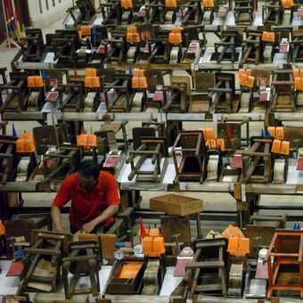 Pekerja membersihkan peralatan linting rokok setelah digunakan buruh linting di unit produksi sigaret keretek tangan di pabrik rokok di Surabaya tahun 2007.