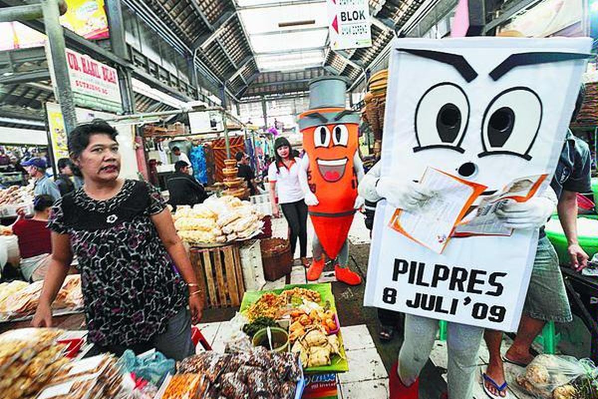 Maskot KPU membagikan selebaran pemilu presiden dan wakil presiden kepada pedagang di Pasar Gede, Solo, Jawa Tengah, Jumat (26/6). Sosialisasi ini diharapkan akan meningkatkan partisipasi masyarakat untuk menggunakan hak pilihnya pada 8 Juli. 