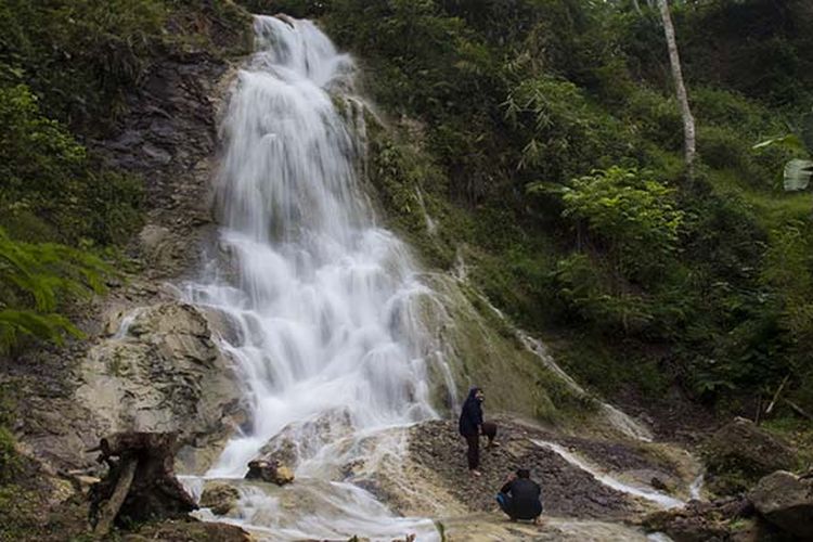 Pengunjung berfoto di depan Air Terjun Kali Miri, kawasan Air Terjun Kembang Soka, Kulon Progo, Yogyakarta.