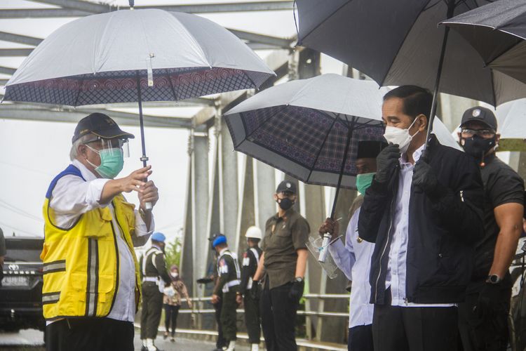 Presiden Joko Widodo (kanan) meninjau langsung lokasi banjir dari atas jembatan Pekauman didampingi Menteri PUPR Basuki Hadimuljono (kiri) di Desa Pekauman Ulu, Kabupaten banjar, Kalimantan Selatan, Senin (18/1/2021). Kunjungan kerja tersebut dalam rangka melihat langsung dampak banjir dan meninjau posko pengungsian korban banjir di Provinsi Kalimantan Selatan. ANTARA FOTO/Bayu Pratama S/aww. 