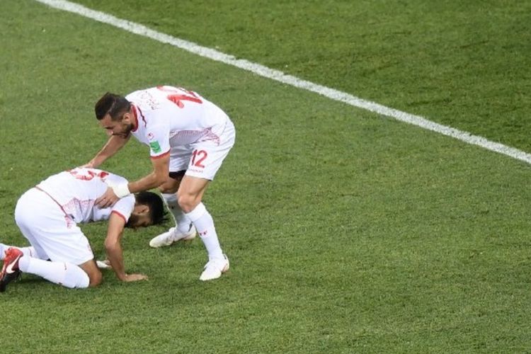 Gelandang Tunisia, Ferjani Sassi, bersyukur seusai mengeksekusi penalti ke gawang Inggris ditemani defender Ali Maaloul pada laga di Volgograd Arena, 18 Juni 2018. 