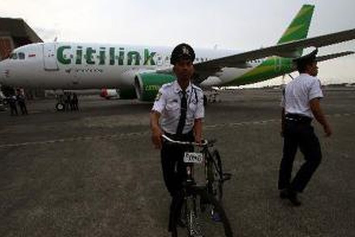 Petugas keamanan melakukan patroli rutin menggunakan sepeda di depan pesawat Airbus A320 Citilink di Hanggar 2 Garuda Maintenance Facilities (GMF) Garuda Indonesia, Bandar Udara Internasional Soekarno-Hatta, Banten, Minggu (26/5/2013).