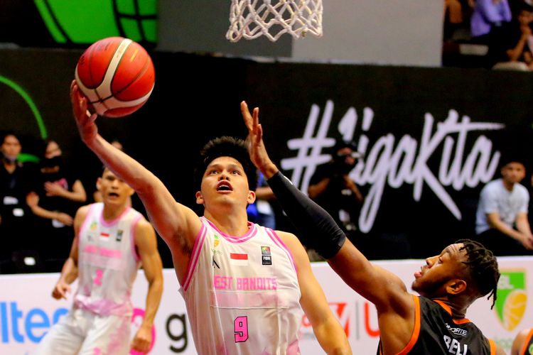 Pebasket West Bandits Solo Rio Disi siap memasukkan bola tapi dijaga pebasket asing Bumi Borneo Basketball Pontianak Randy Bell saat pertandingan seri II Malang IBL 2023 yang berakhir dengan skor 79 - 75 di GOR Bimasakti Malang, Sabtu (28/1/2023) malam.