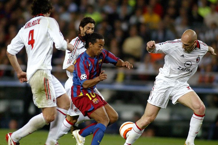 Pemain Barcelona Brazilain Ronaldinho (tengah) mencoba mengoper AC Milan Jaap Stam (kanan) selama pertandingan sepak bola leg kedua semifinal Liga Champions di stadion Camp Nou di Barcelona, 26 April 2006.