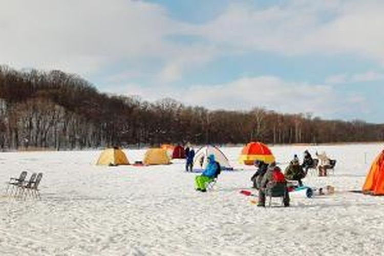 Beberapa pemancing duduk di depan tenda mereka yang didirikan di permukaan Danau Abashiri yang membeku, Selasa (4/2/2014), di Hokkaido bagian timur. Memancing di atas permukaan danau membeku merupakan salah satu atraksi menarik di Abashiri.