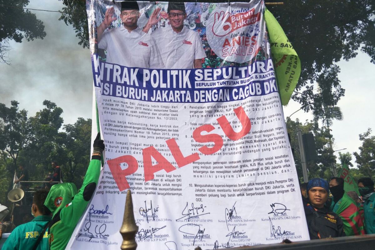 Spanduk berisi kontrak politik yang disebut-sebut ditandatangani oleh Gubernur DKI Jakarta Anies Baswedan dan para buruh. Spanduk dibawa buruh saat demo di depan Balai Kota DKI Jakarta, Jumat (10/11/2017). 