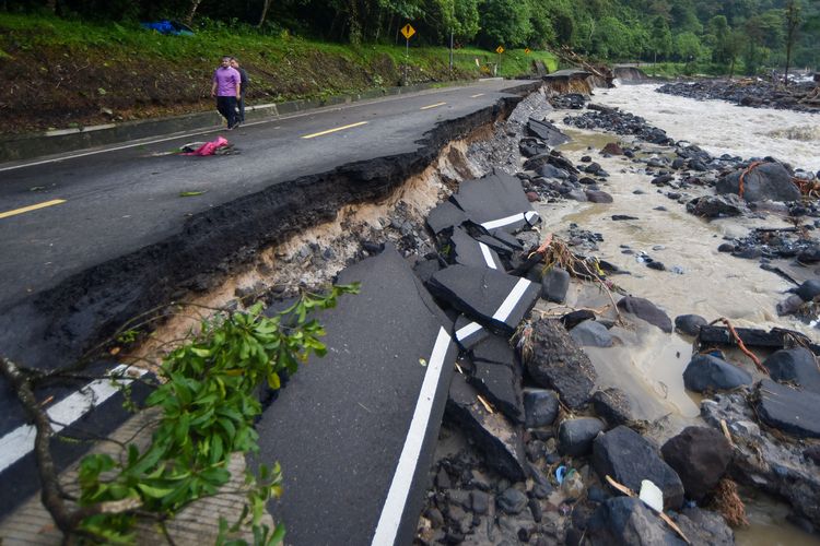 Warga melihat jalan yang putus di wilayah Mega Mendung, Lembah Anai, Tanah Datar, Sumatera Barat, Sabtu (29/11/2025). Akses utama jalan nasional Padang-Bukittinggi itu putus total akibat banjir bandang dan longsor pada Kamis (27/11) sehingga pengguna jalan harus memutar jauh melalui Kabupaten Solok. ANTARA FOTO/Iggoy el Fitra/tom.