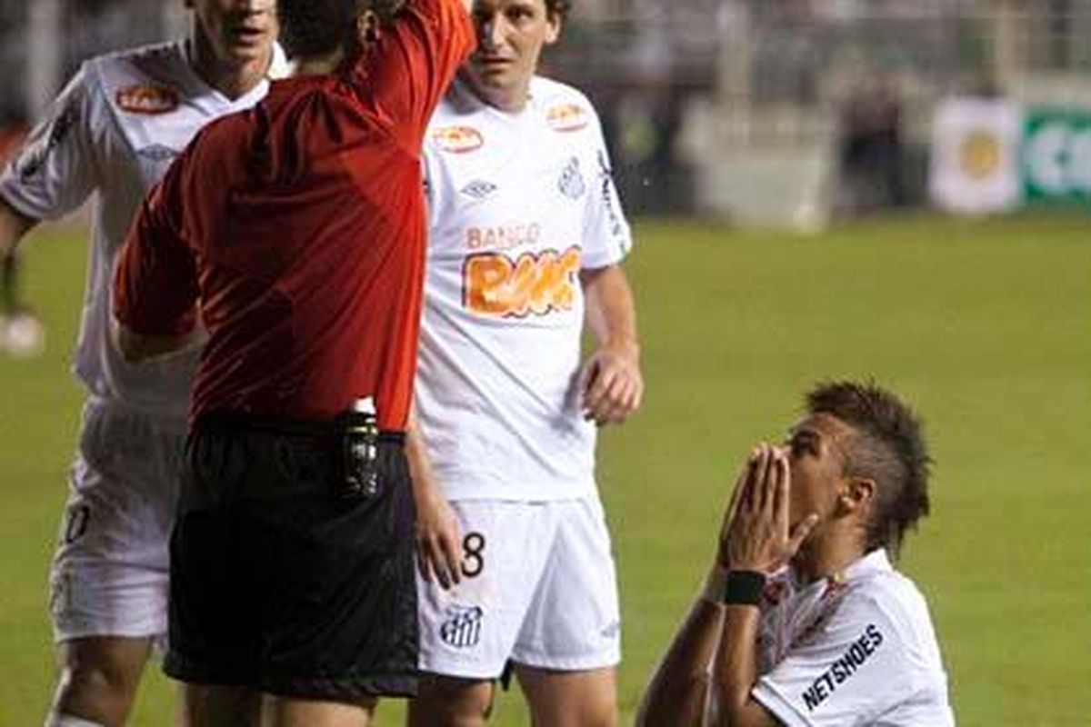 Pemain Santos, Neymar (kanan), berlutut saat menerima kartu kuning kedua yang menyebabkan ia diusir dari lapangan pada laga Piala Libertadores antara Santos dan Colo Colo di  Santos, Brasil, Rabu (6/4).