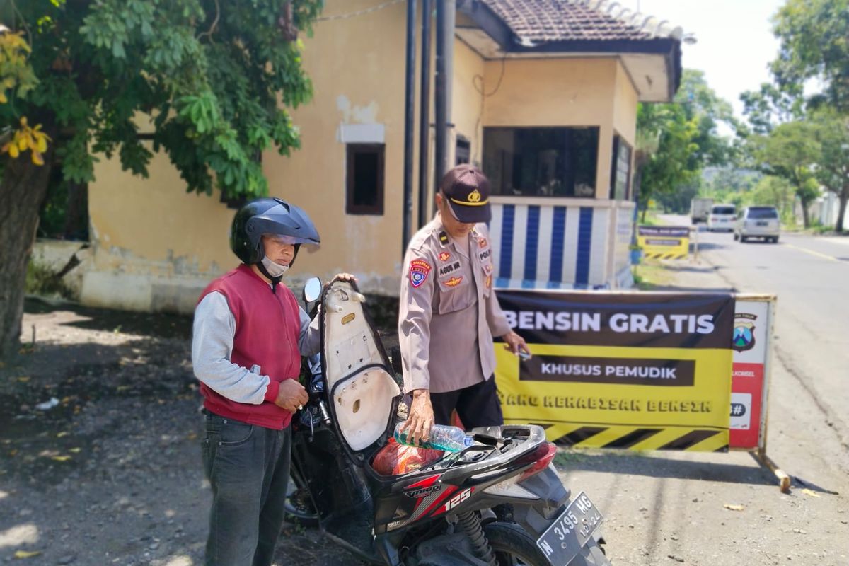 Foto: Petugas kepolisian ketika mengisi bensin pemudik di Jalan Pantura Situbondo.