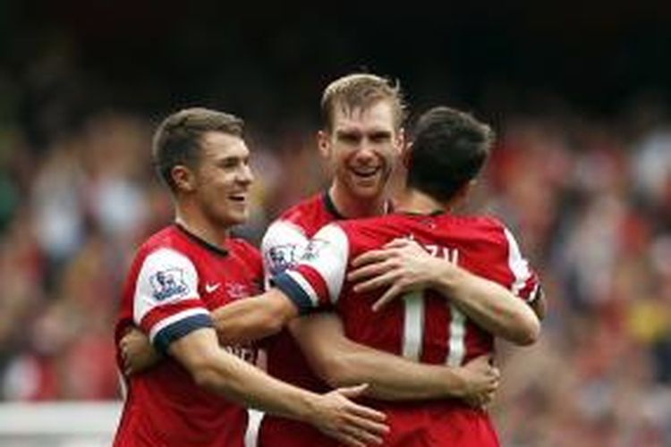 Bersama gelandang Aaron Ramsey (kiri) dan Mesut Oezil, bek Arsenal Per Mertesacker (tengah) merayakan golnya ke gawang Stoke City, pada pertandingan Premier League, di Emirates, Minggu (22/9/2013). 