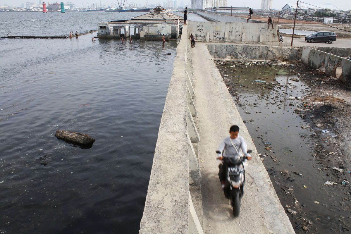 Warga melintas di areal tanggul laut, Muara Baru, Jakarta Utara, Sabtu (12/10/2019). Pemerintah Provinsi DKI Jakarta dan Kementerian Pekerjaan Umum dan Perumahan Rakyat (PUPR) mengambil alih pembangunan segmen tanggul laut National Capital Integrated Coastal Development ( NCICD) di utara Jakarta.