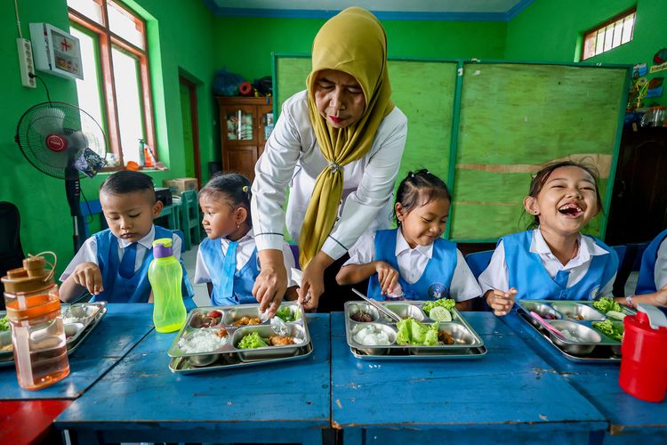 Sejumlah siswa menyantap hidangan paket Makan Bergizi Gratis (MBG) di TK Pertiwi, Tanjunganom, Nganjuk, Jawa Timur, Senin (20/10/2025). Menurut Presiden Prabowo Subianto, program MBG telah menjangkau 36,2 juta penerima manfaat dengan total lebih dari 1,3 hingga 1,4 miliar porsi makanan yang telah disalurkan kepada masyarakat.