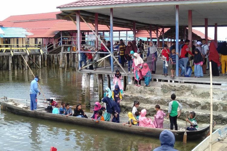 Suasana lebaran di Desa Torosiaje, warga menaiki perahu untuk berkunjung ke kerabat atau tetangganya.