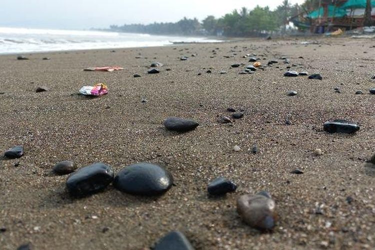 Ceceran batu bara mengotori Pantai Cipatuguran Batu Bintang, Desa Jayanti, Kecamatan Palabuhanratu, Selasa (23/8/2022). 
