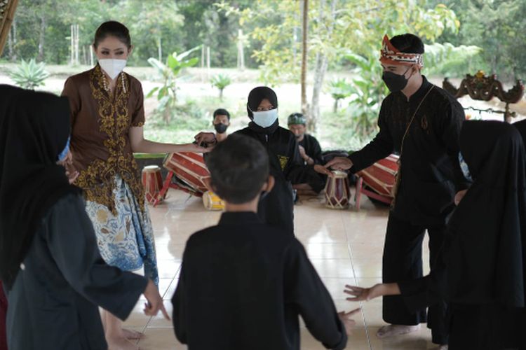 Para wisatawan sedang mencoba permainan tradisional di Alamendah, Kabupaten Bandung.