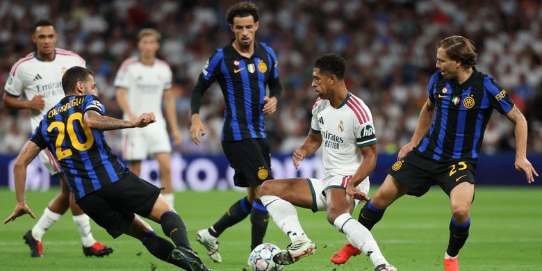 Jude Bellingham (tengah) dibayangi Hakan Calhanoglu dan Nicolo Barella (kanan) dalam pertandingan sepak bola Liga Champions Real Madrid vs Inter Milan di Stadion Santiago Bernabeu di Madrid pada 8 September 2026. (Foto oleh Pierre-Philippe MARCOU / AFP)