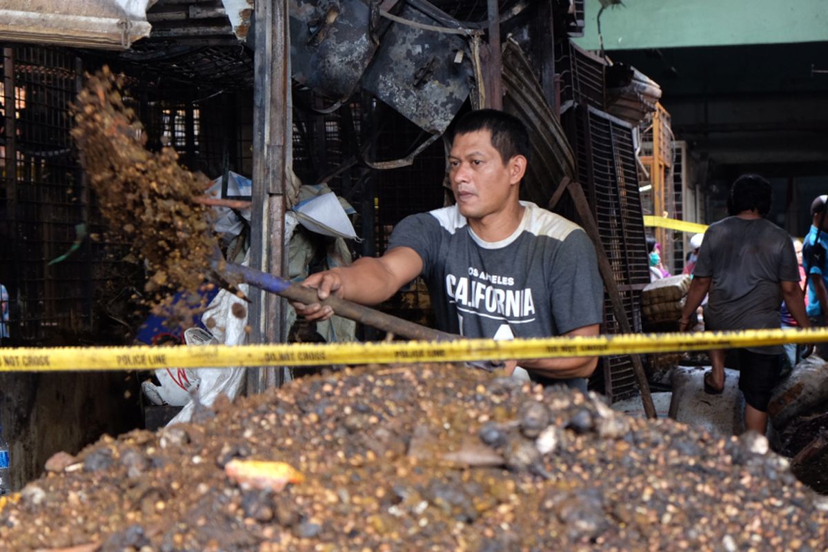 Pedagang Korban Kebakaran Membersihkan Kiosnya yang Terbakar di Pasar Induk Keramat Jati, Jakarta Timur, Senin (12/6/2017).
