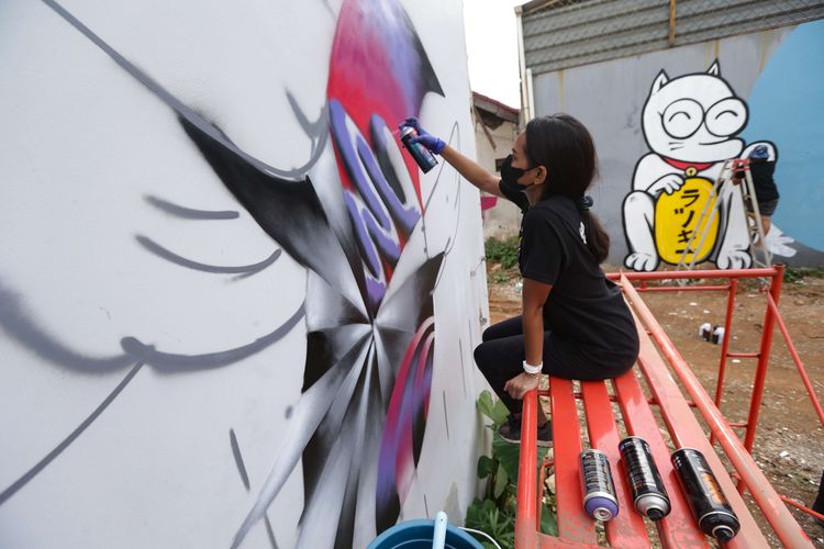 Seniman jalanan Bunga Fatia menyelesaikan pembuatan mural dalam acara On & Off Pressure di Jakarta Barat, Senin (8/11/2021). Kegiatan seni ini mengajak 10 seniman jalanan atau street artist  berkolaborasi melukis mural bersama di dalam satu kawasan di wilayah kota Tangerang.