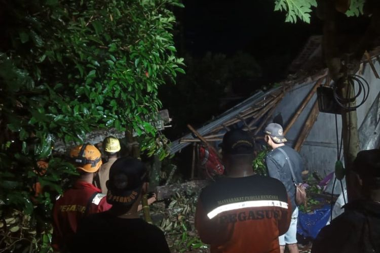 BPBD dan warga gotong royong evakuasi pohon tumbang akibat hujan deras disertai angin kencang di Kapanewon Kalibawang, Kulon Progo, Daerah Istimewa Yogyakarta, Kamis (17/2/2022).