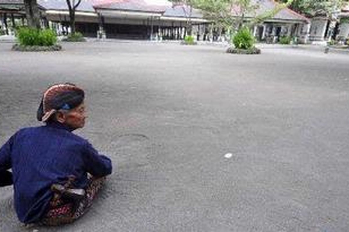 Abdi dalem Darno Pawoko berjaga di seberang Bangsal Kencono di kompleks Keraton Yogyakarta, Yogyakarta, Kamis (18/11/2010), yang sepi pengunjung. Pascaerupsi Gunung Merapi, jumlah rata-rata wisatawan domestik yang berkunjung ke keraton tersebut turun dari 1.500 menjadi sekitar 150 orang per hari. Jumlah wisman yang berkunjung juga turun dari rata-rata 300 menjadi 70 wisatawan per hari.