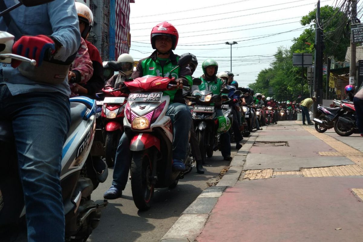 Petugas kepoliian dari NTMC Polri memberikan penyuluhan pada pengendara yang menggunakan trotoar tidak sesuai peruntukannya pada kampanye Gerakan Tertib Lalu lintas Kompas Otomotif dan Otomania