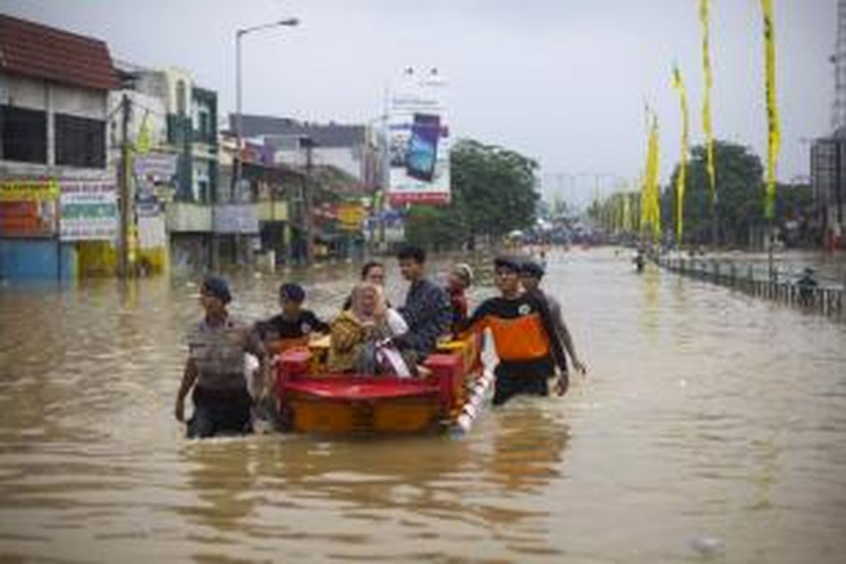 Luapan Kali Ciliwung memutus jalur kendaraan di Jalan KH Abdullah Syafi'ie, Tebet, Jakarta Selatan, Senin (13/1/2014). Luapan kali mulai menggenangi permukiman dan memutus jalan sejak Senin dini hari. KOMPAS/AGUS SUSANTO