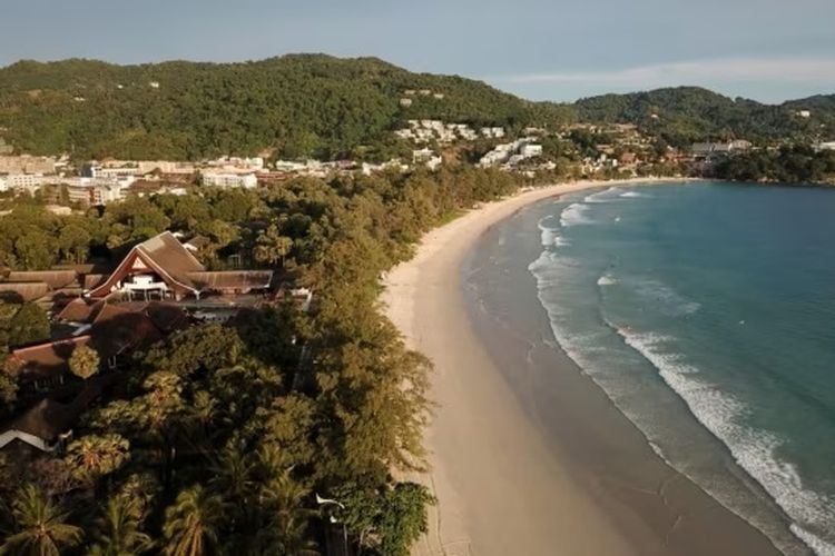 Orang-orang berjalan di Pantai Kata di Phuket, Thailand, 1 Juli 2021.