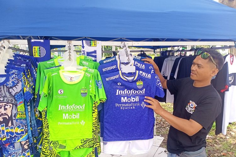 Wahyu (33) tetap berjualan kaos Persib Bandung meski laga penyisihan Group C Piala Presiden 2022 antara Persib Bandung vs Bhayangkara FC di gelar tanpa penonton.